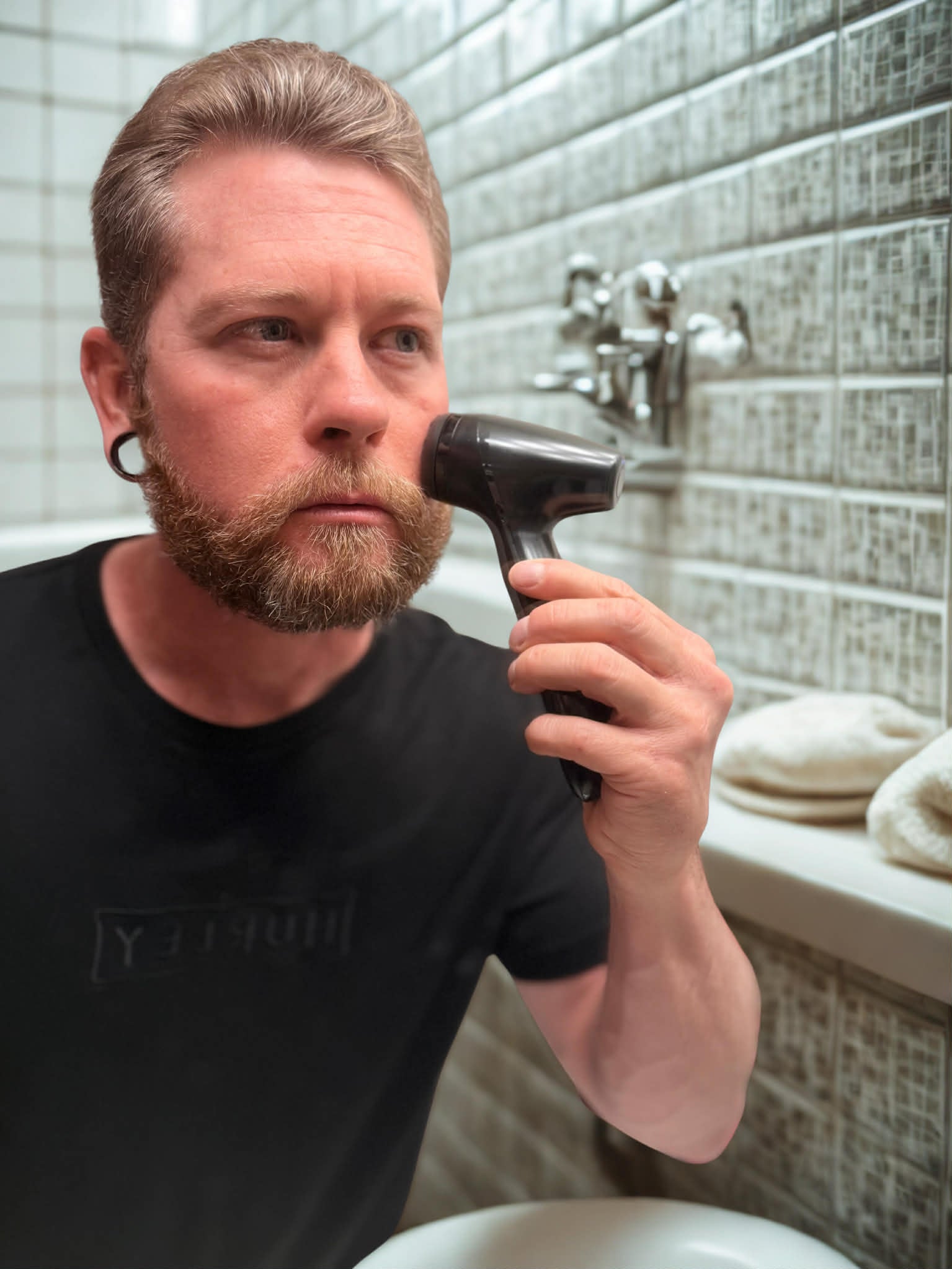 Man using a Black LumiSpa in a bathroom setting