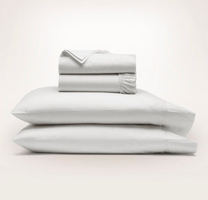 Boll & Branch Signature Hemmed Sheet Set in white/pewter stripe on bed